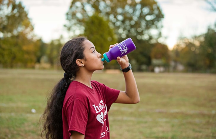 A Girls on the Run participant stretches at program practice to prepare for the day. A Girls on the Run participant stretches at program practice to prepare for the day.
